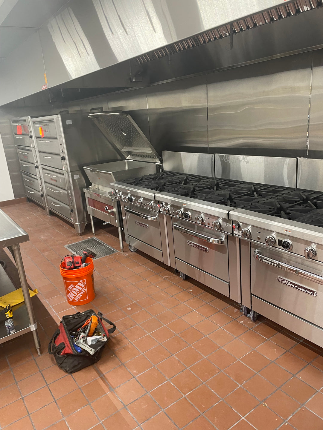 line up cooking equipment under 20-foot hood for mass production in a church kitchen