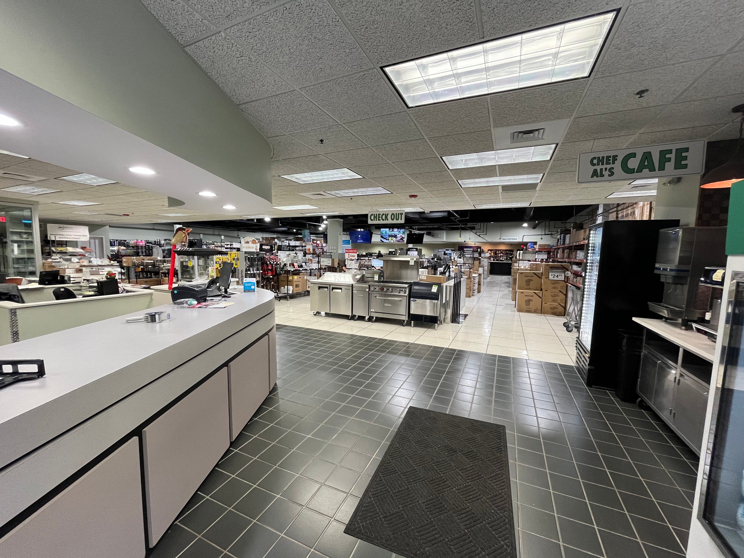 view of walking in the front entrance of our Lisle Superstore seeing our showroom/design center, free beverage station, product for sale, offices and test kitchen area.