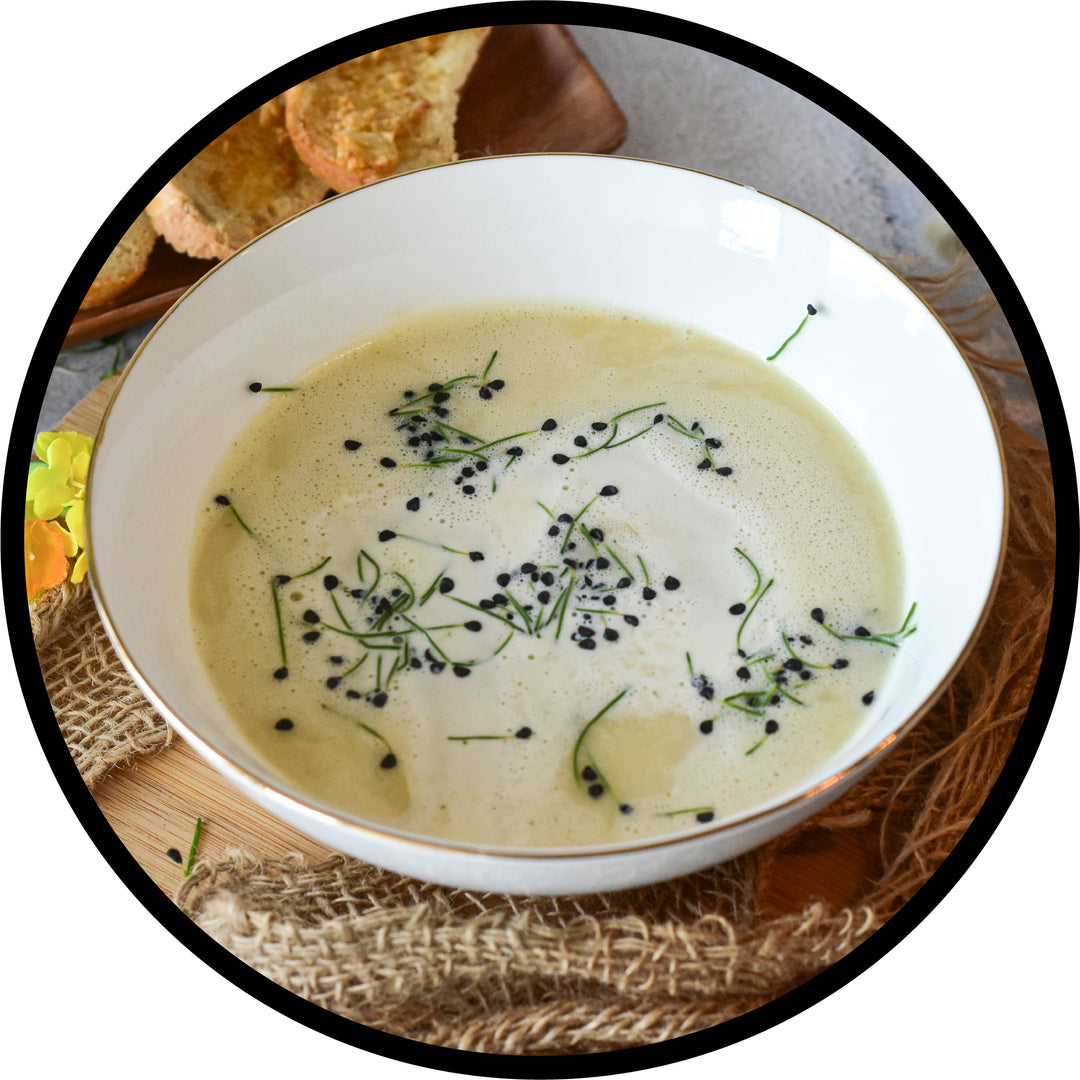 Creamy soup garnished in a fancy white, gold-rimmed china bowl