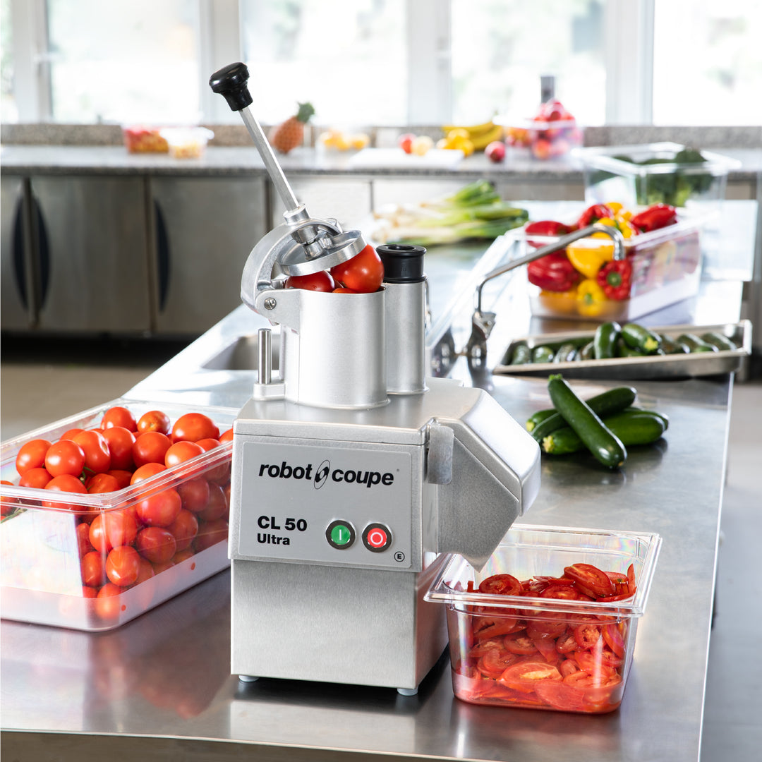 Robot Coupe CL50 Ultra Vegetable Preparation Machine in use on a commercial kitchen work table