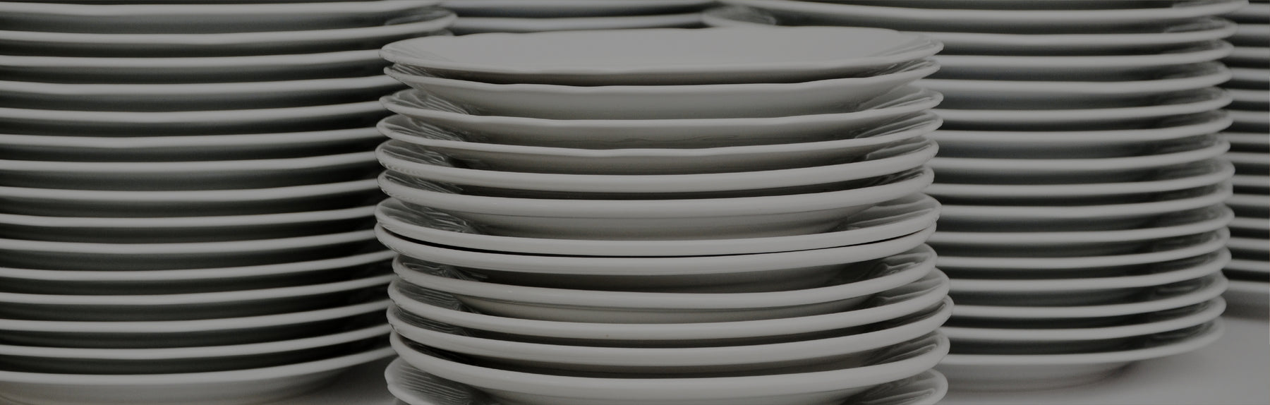 Stacks of white china dinner plates